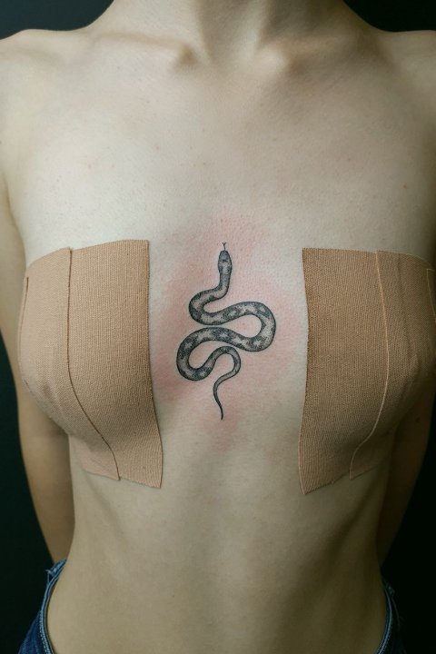 tatuaż między piersiami
